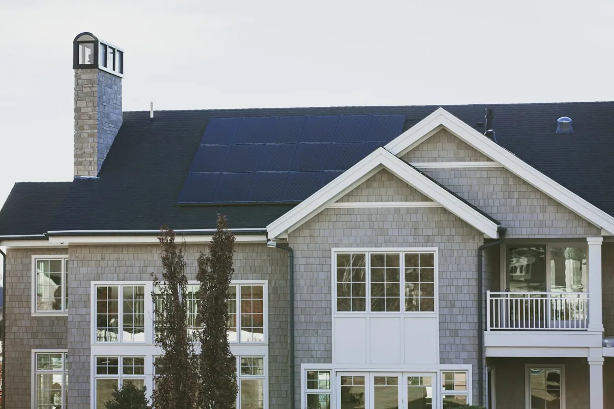 A gray house with a full array of solar panels on the roof